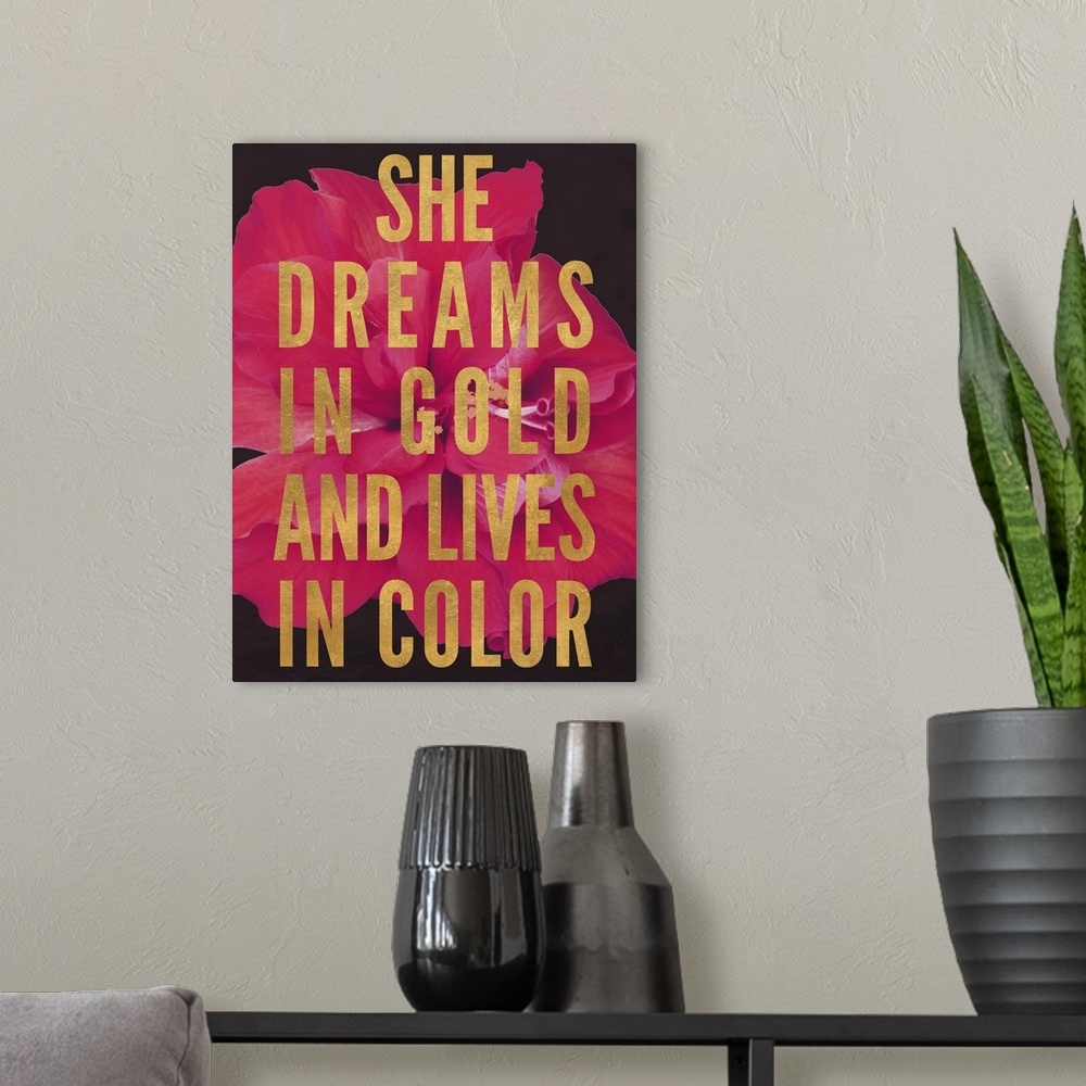 A modern room featuring Block text that reads "She dreams in gold and lives in color" over an image of a red flower.