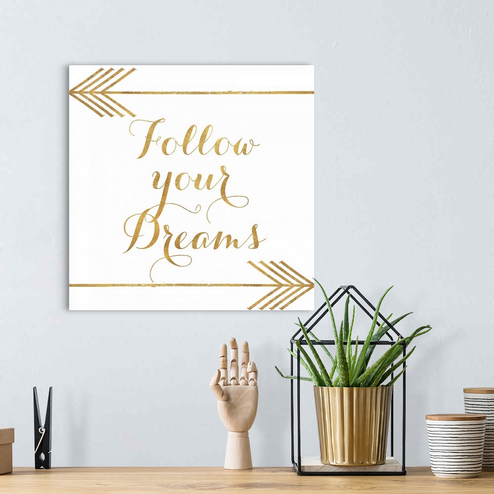 A bohemian room featuring "Follow Your Dreams" written in gold with two gold arrows.
