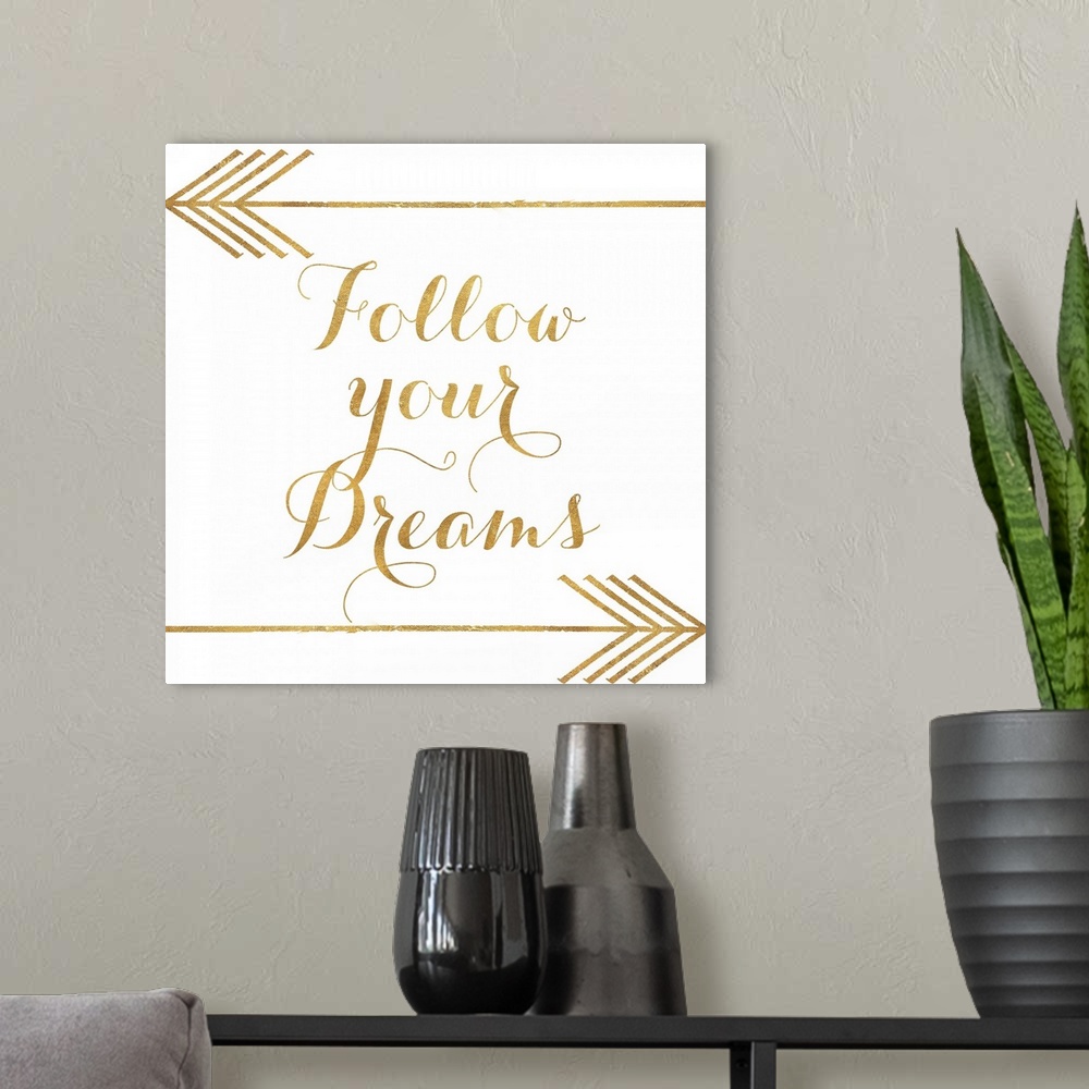 A modern room featuring "Follow Your Dreams" written in gold with two gold arrows.