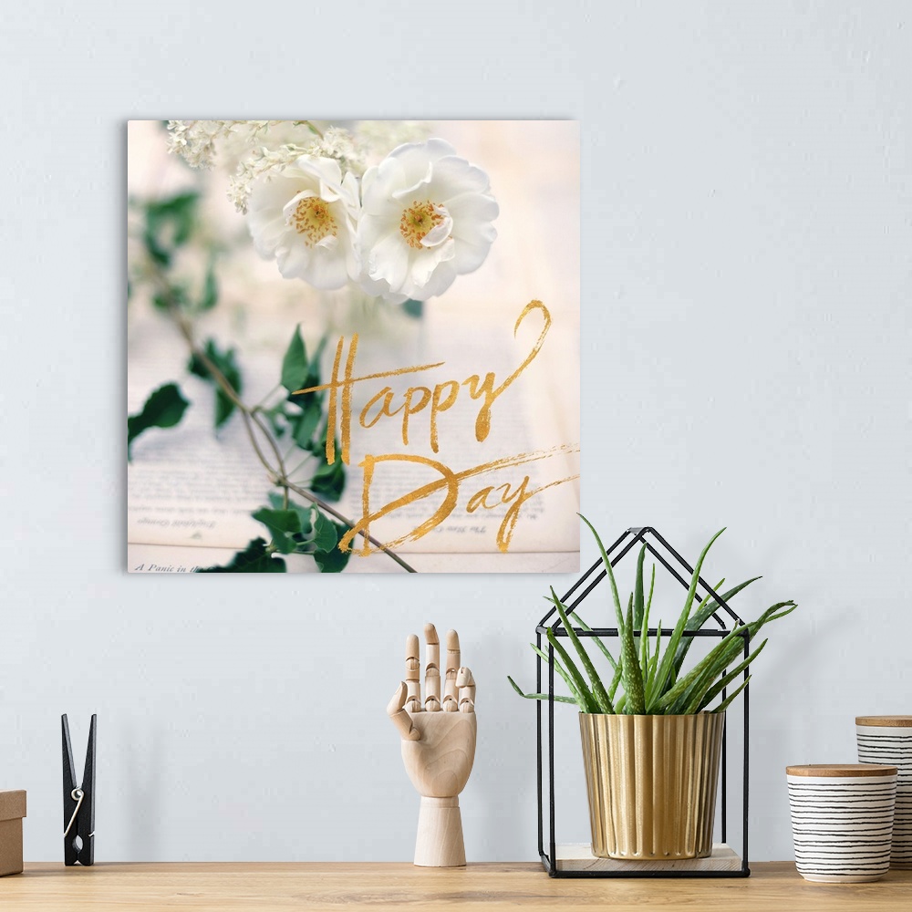 A bohemian room featuring A photograph of white flowers, green leaves, and two book pages with an overlay of golden text re...