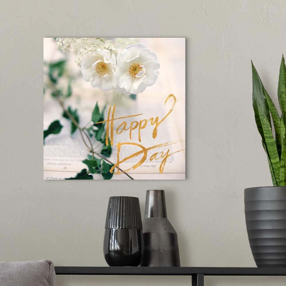 A modern room featuring A photograph of white flowers, green leaves, and two book pages with an overlay of golden text re...