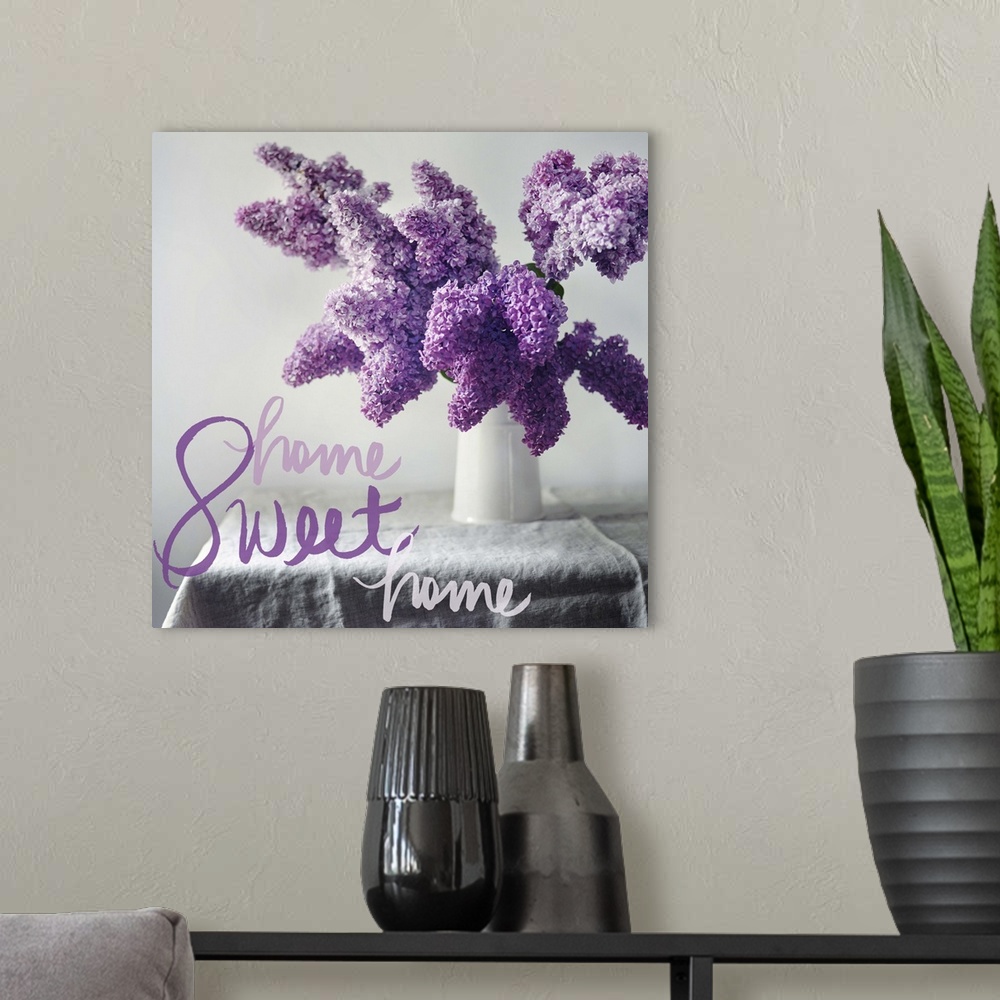 A modern room featuring A photograph of purple hydrangeas in a white vase on a table with the phrase "Home Sweet Home" wr...