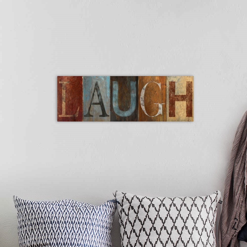 A bohemian room featuring Horizontal home art docor on a big canvas of the word "LAUGH" , each letter is a different color ...