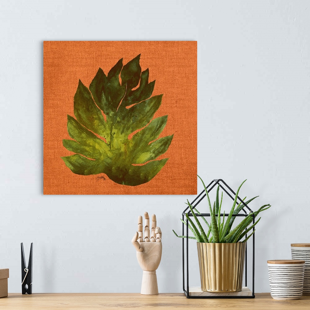 A bohemian room featuring Square painting of a big green leaf on an orange burlap background.