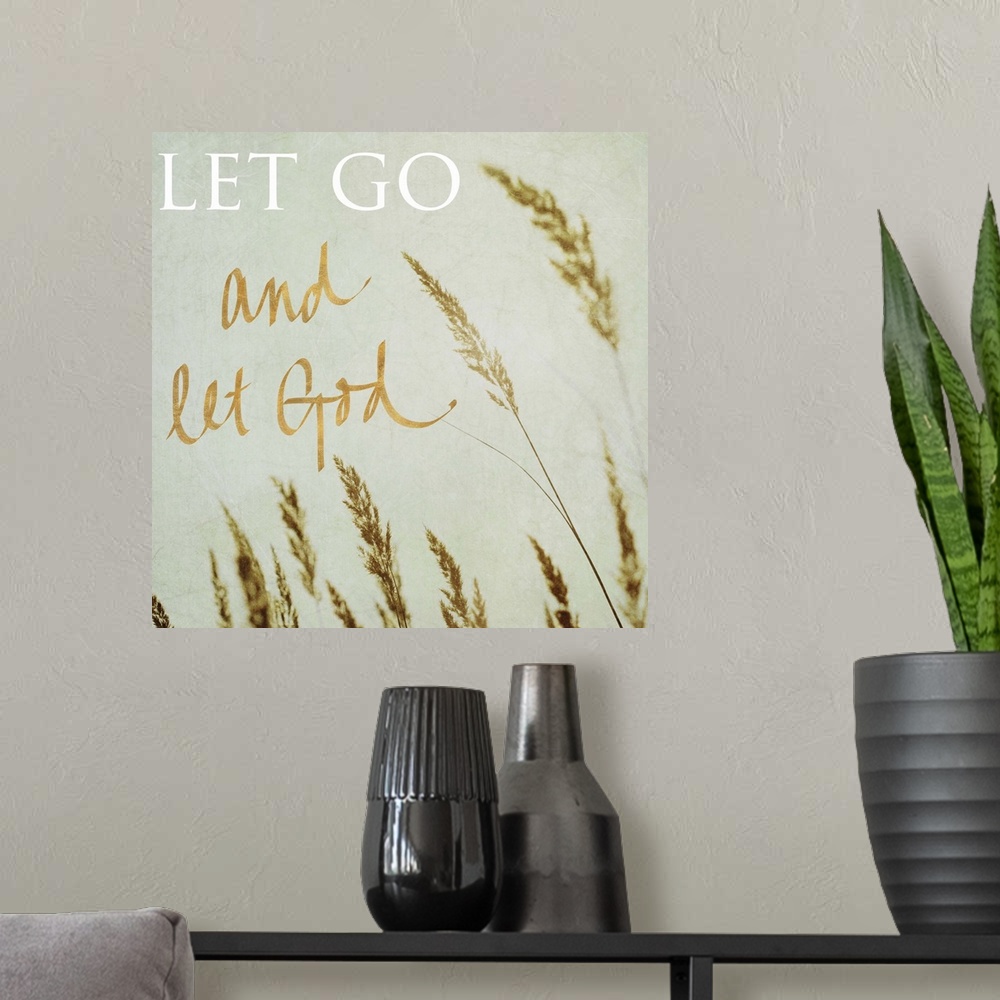 A modern room featuring Square photograph of the tips of beach grass swaying in the wind with the quote "Let Go and Let G...