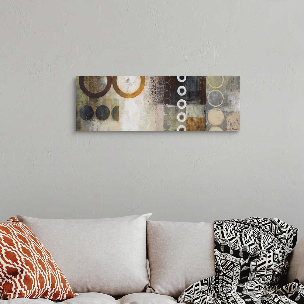 A bohemian room featuring Panoramic abstract painting of different sized circles over top of a grungy background.