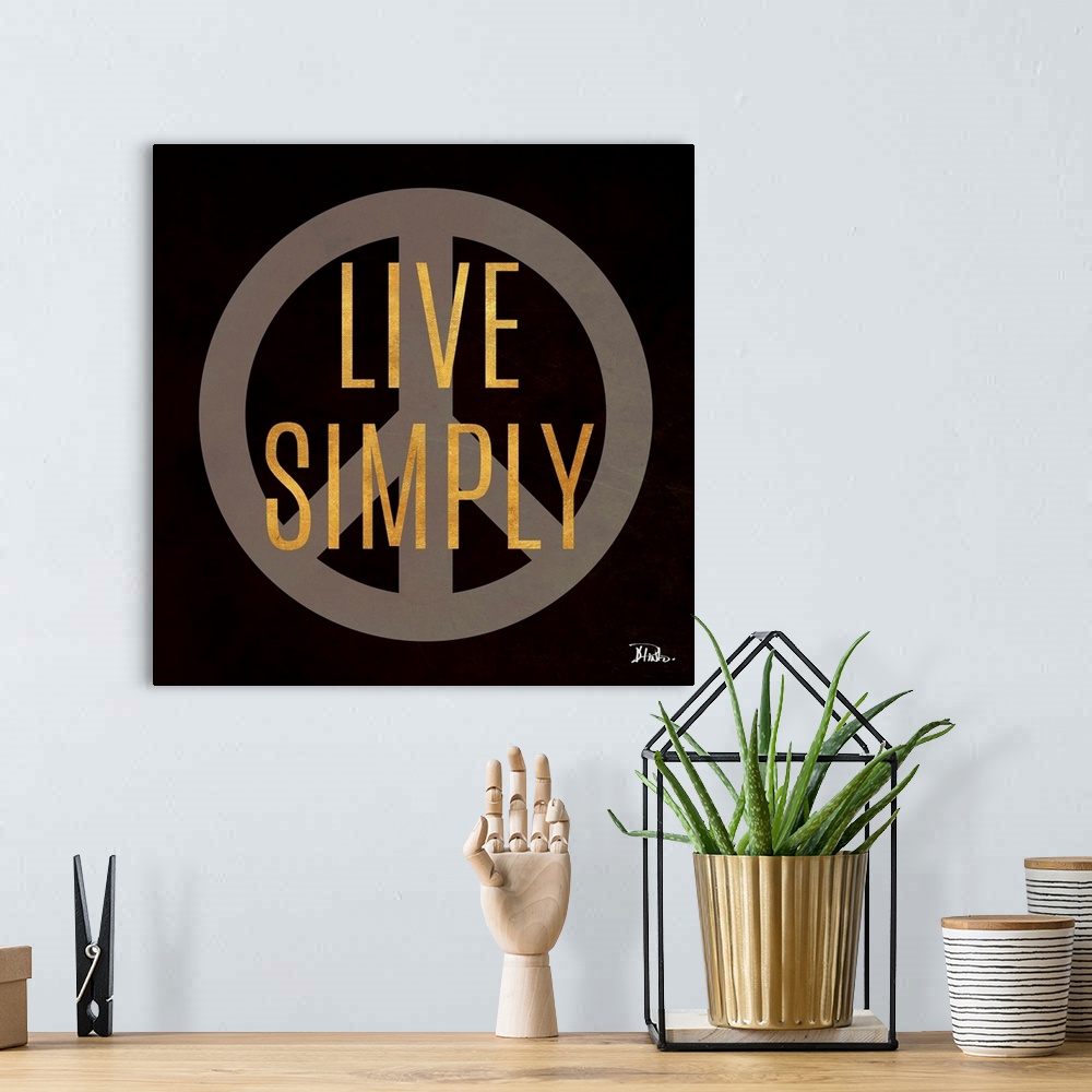 A bohemian room featuring The words "Live Simply" in gold over a peace sign against a black background.