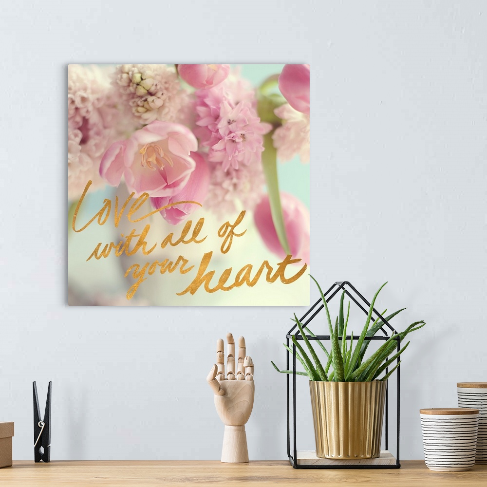 A bohemian room featuring A photograph of pink and white flowers with the text "Love With All of Your Heart" written in gol...