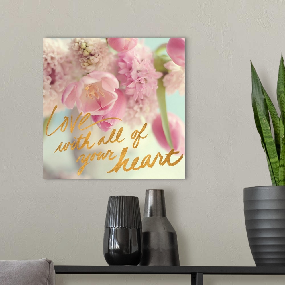 A modern room featuring A photograph of pink and white flowers with the text "Love With All of Your Heart" written in gol...