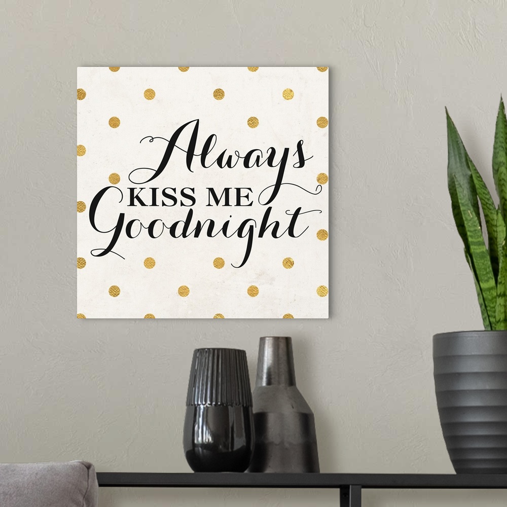 A modern room featuring The words "Always Kiss Me Goodnight" in black script on a cream background with gold dots.