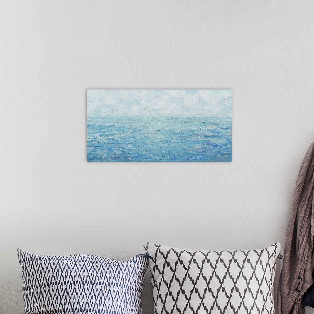 A bohemian room featuring Contemporary artwork of a blue seascape with a cloudy sky.