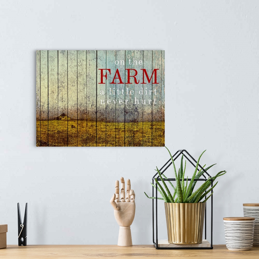 A bohemian room featuring Wood paneled painting farmland with a yellow barn and the saying "On the Farm a little dirt never...