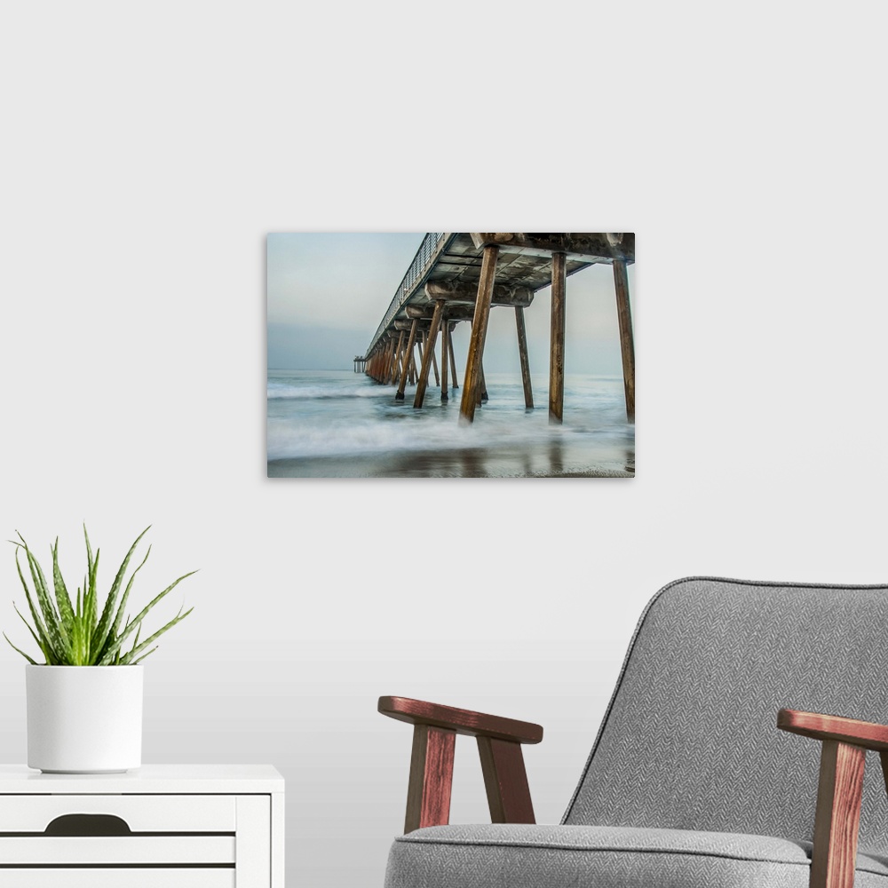 A modern room featuring View from below of a wooden pier stretching out into the ocean.