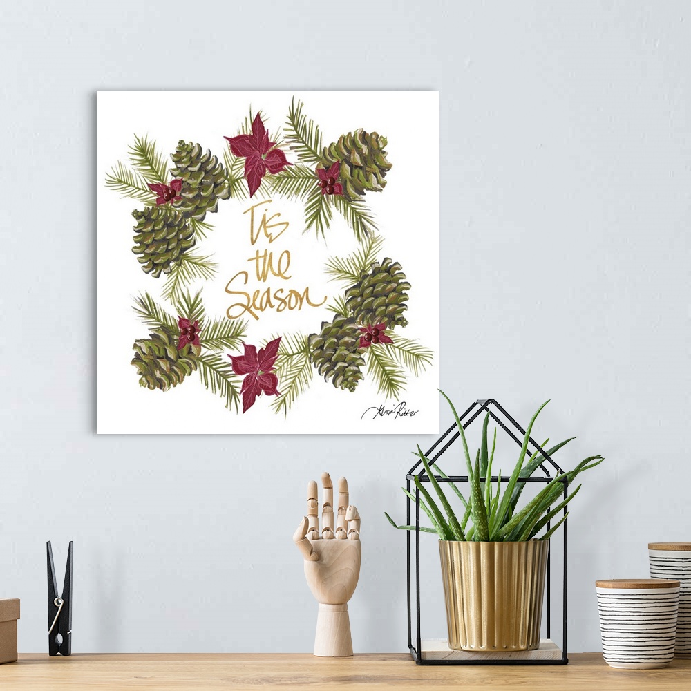A bohemian room featuring Golden lettering in the center of a wreath made of pinecones and poinsettias.