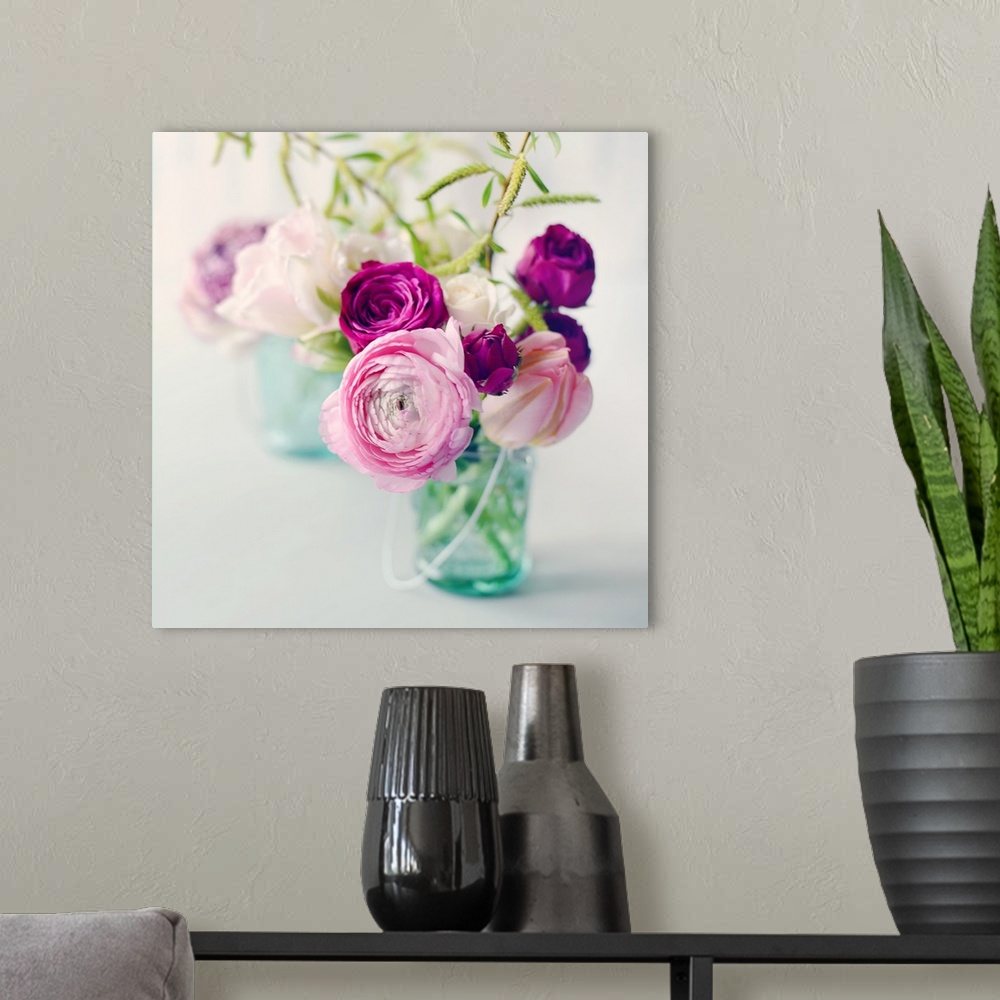 A modern room featuring A photograph of pink, white, and purple flower arrangements in blue tinted mason jars.