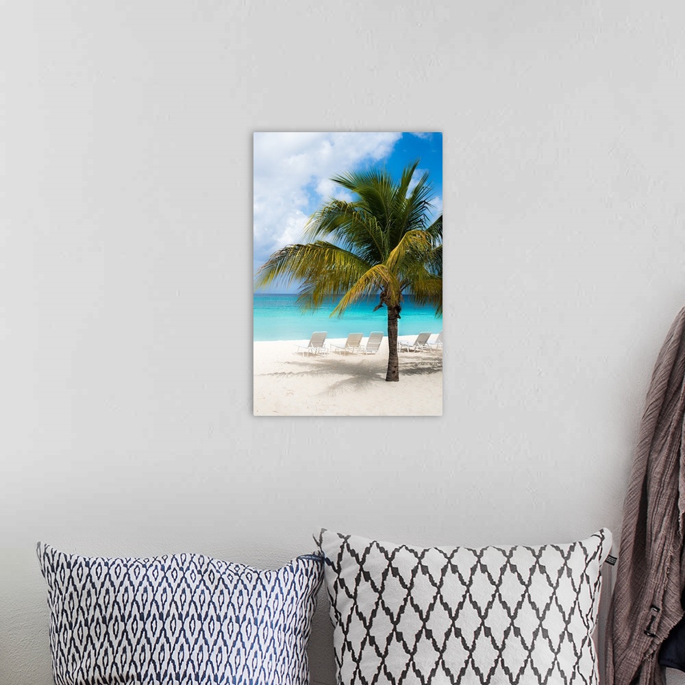 A bohemian room featuring A beautiful photograph of the calm, clear, blue beach with white sands and a palm tree.