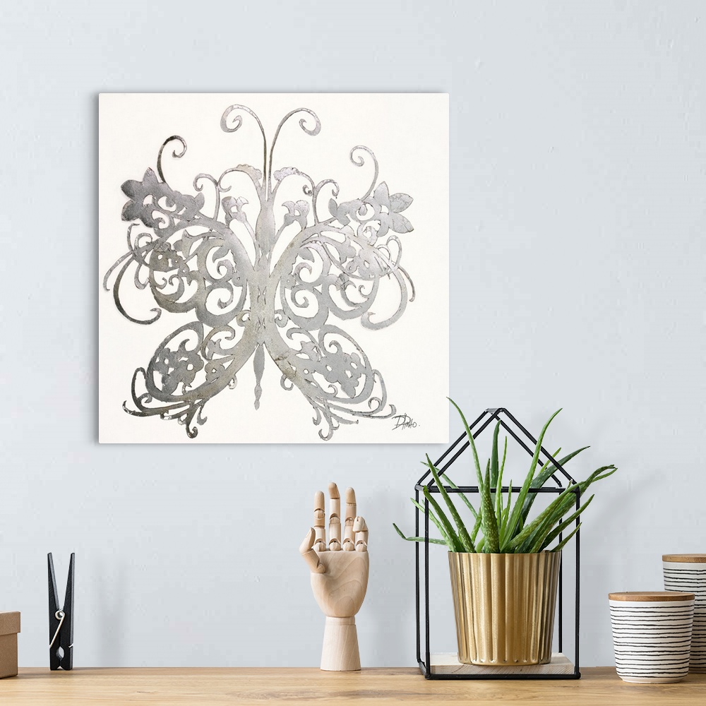 A bohemian room featuring A shiny silver designed butterfly on a solid white background.