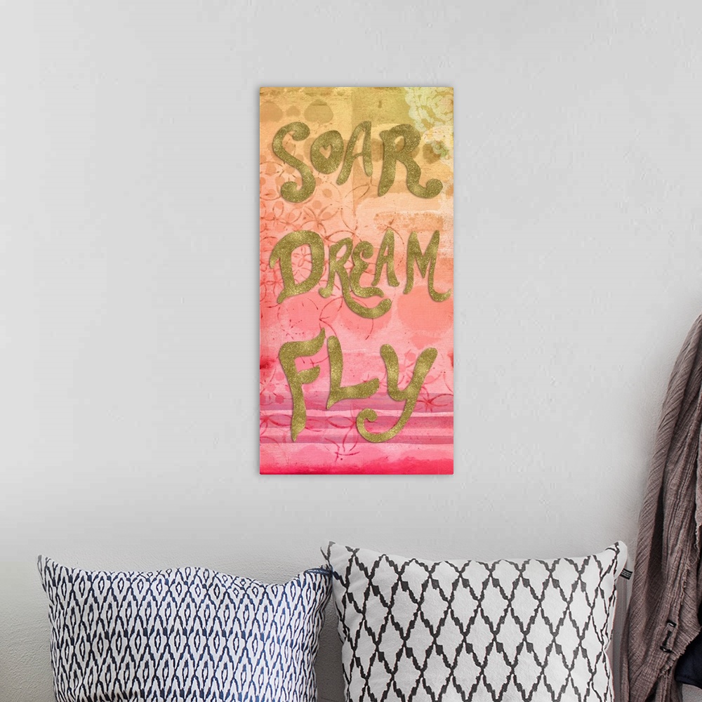 A bohemian room featuring "Soar Dream Fly" written in metallic gold on a yellow, orange, and pink fading background with li...