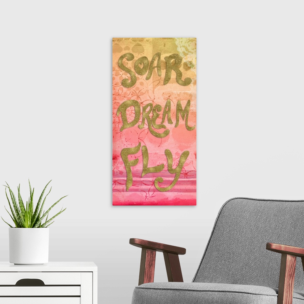 A modern room featuring "Soar Dream Fly" written in metallic gold on a yellow, orange, and pink fading background with li...
