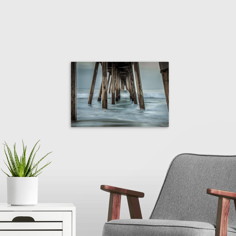 A modern room featuring View from below of a wooden pier stretching out into the ocean.