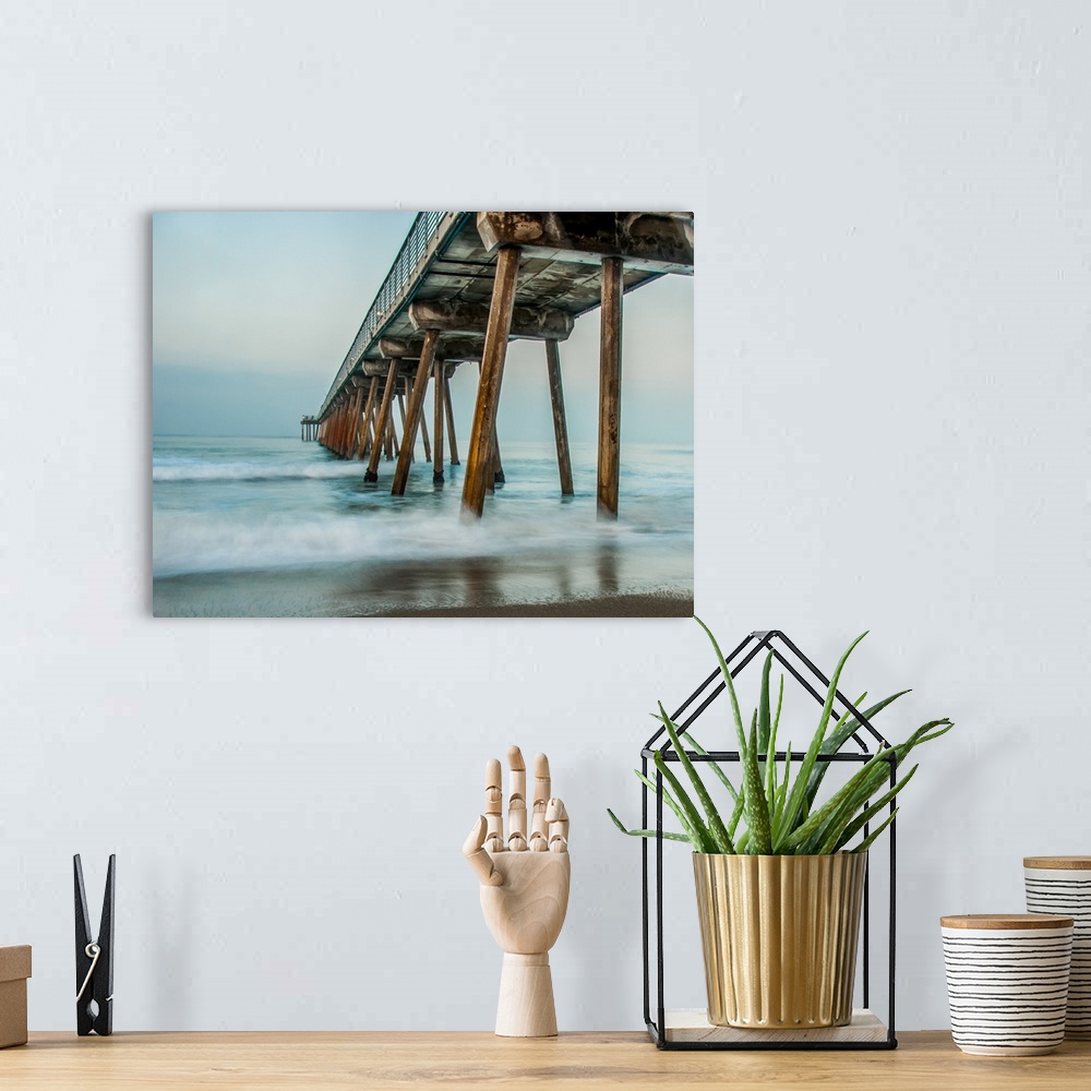 A bohemian room featuring View from below a wooden pier stretching out into the ocean.