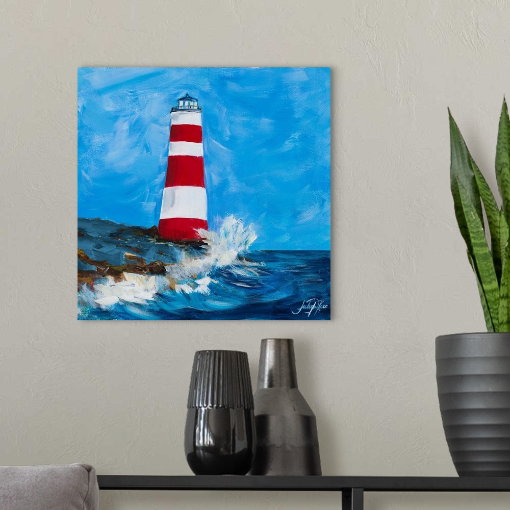 A modern room featuring Square painting of a red and white striped lighthouse on the coastline with waves crashing up on it.