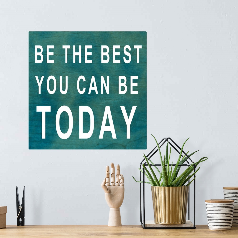 A bohemian room featuring Square, large inspirational artwork of big text that reads "Be the best you can be today", on a b...
