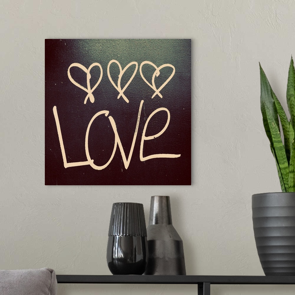 A modern room featuring The word "Love" with three little hearts above written on a dark surface.