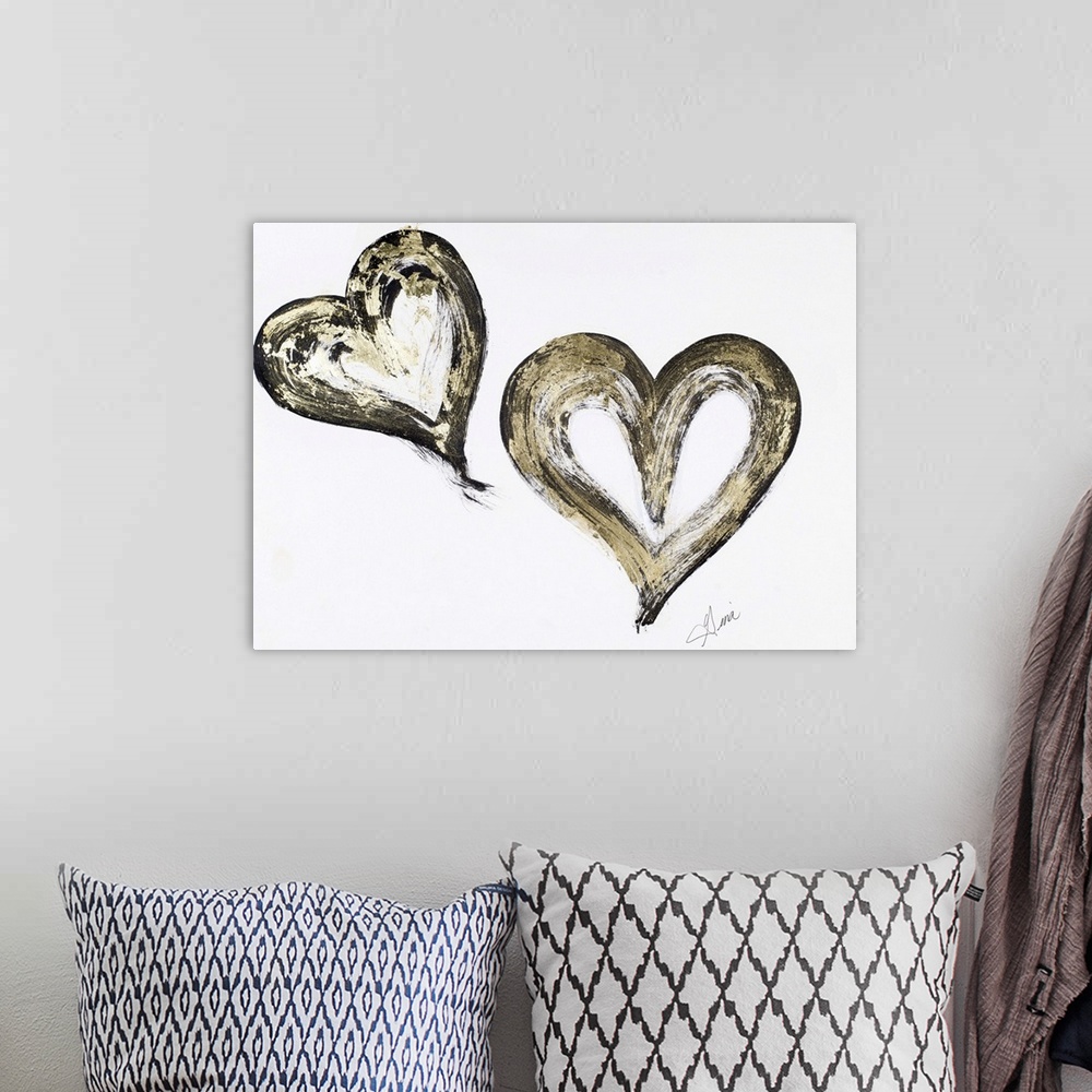 A bohemian room featuring A painting of two black and gold hearts.