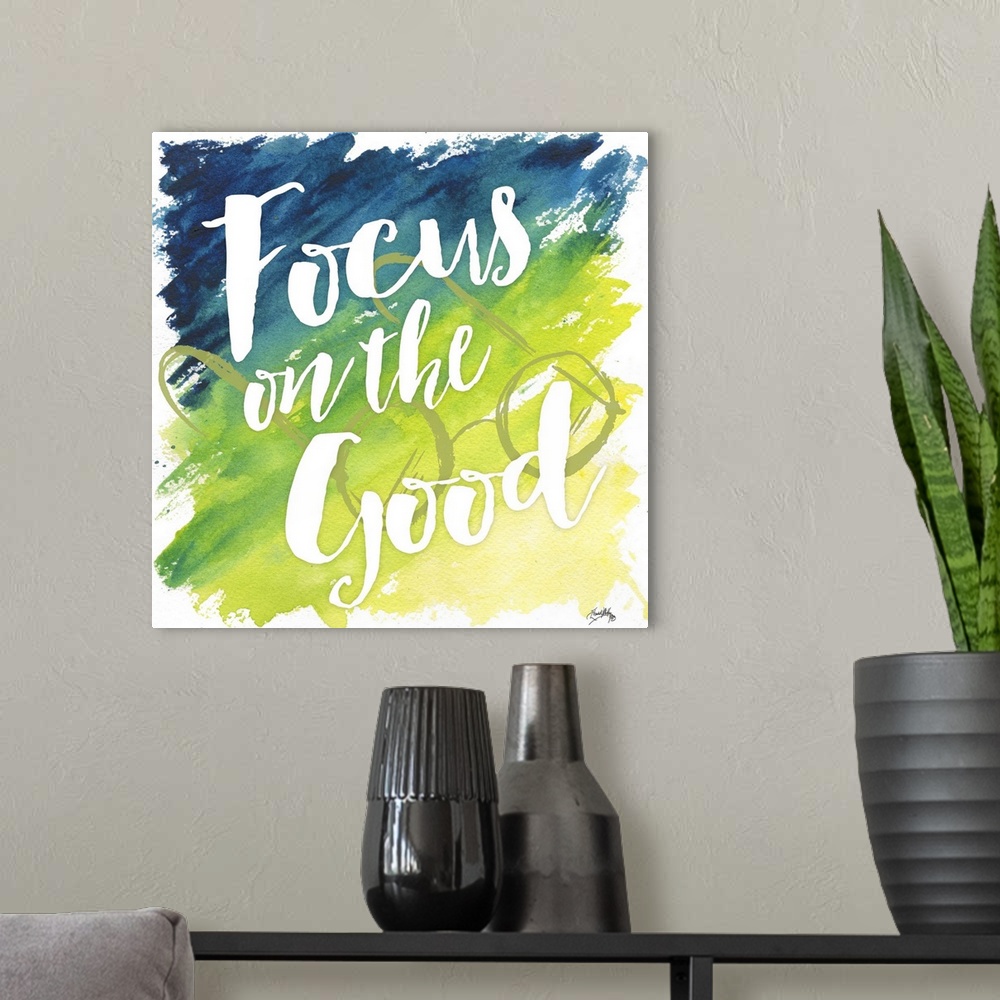 A modern room featuring "Focus on the Good" on a blue to yello gradient watercolor background with circular framed eyegla...