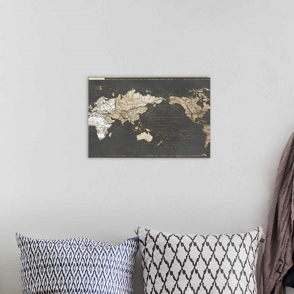 A bohemian room featuring A gold and gray map of the world written in French.