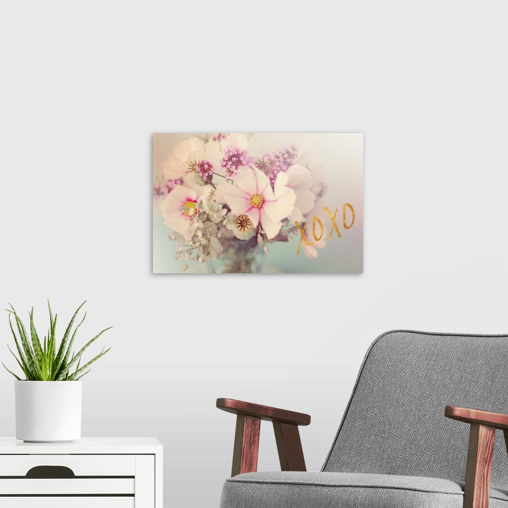 A modern room featuring Soft, pink toned photograph of flowers arranged in a vase with "XOXO" written in gold on the side.