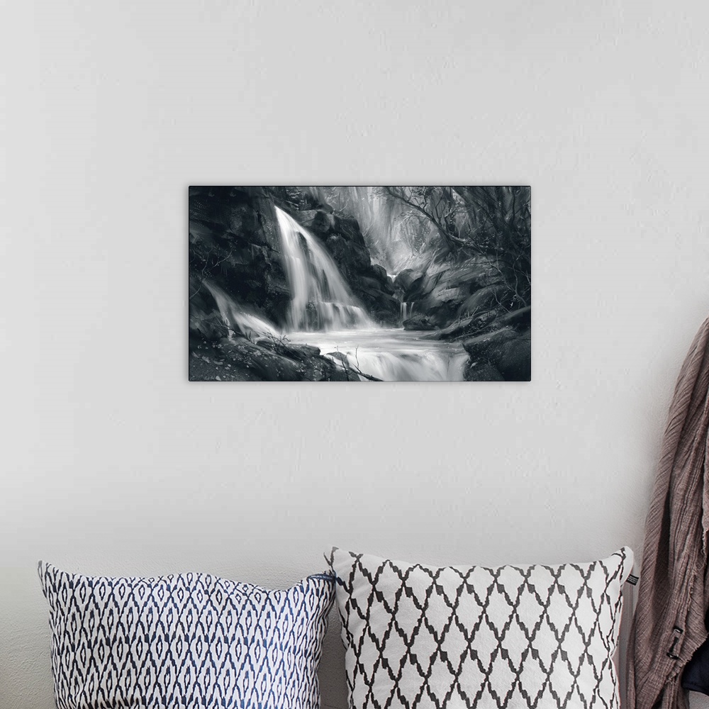 A bohemian room featuring Monochrome painting of waterfall scene in forest.