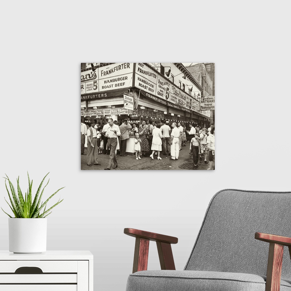 A modern room featuring A crowd outside of Nathan's Famous in Coney Island, Brooklyn, New York. Photograph by Al Aumuller...