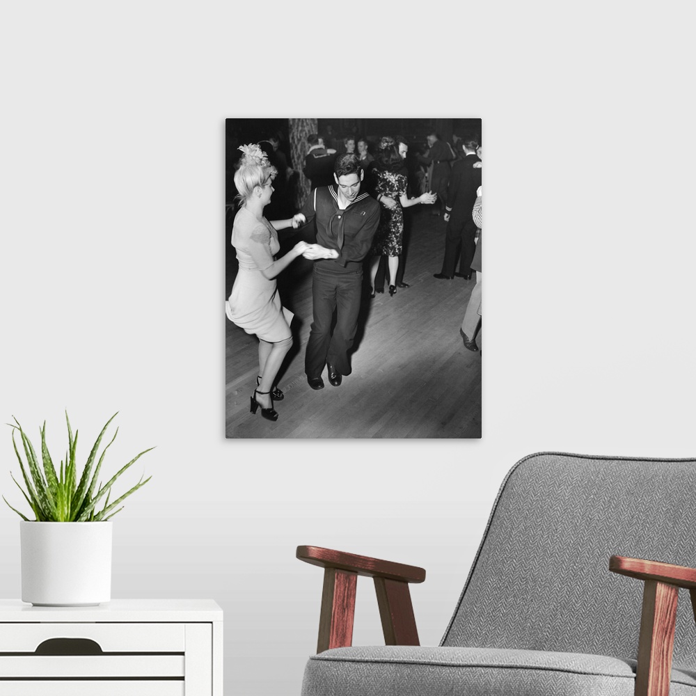 A modern room featuring A sailor and his girlfriend dance the Jitterbug at the Hurricane dancehall in New York City. Phot...