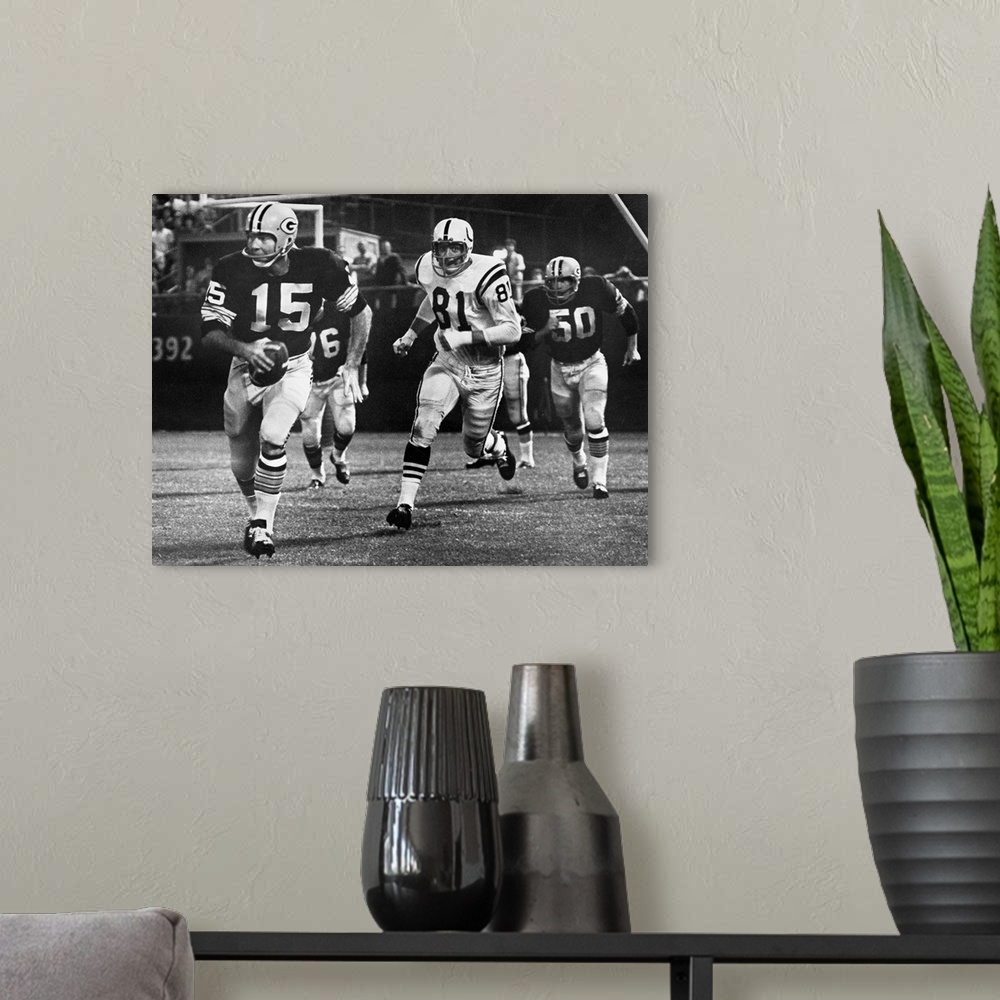A modern room featuring Quarterback Bart Starr of the Green Bay Packers attempting to run for a first down against the Ba...