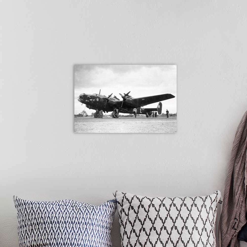 A bohemian room featuring Crew members service a Handley Page Halifax bomber plane of the British Royal Air Force.