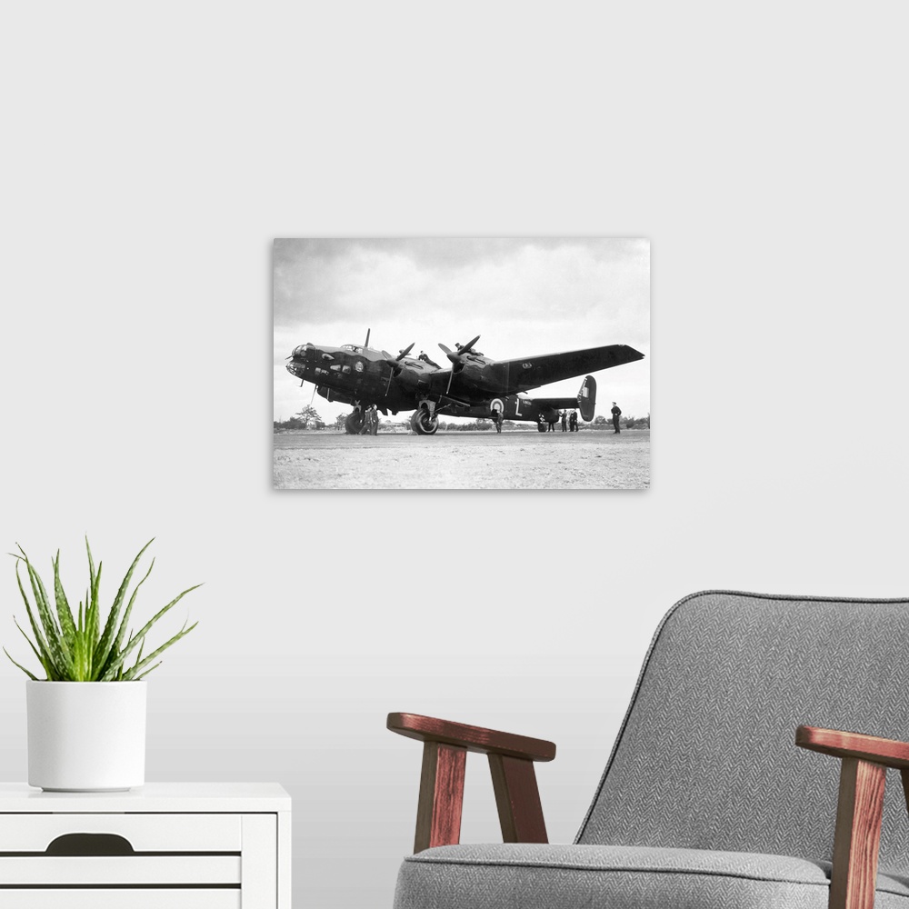 A modern room featuring Crew members service a Handley Page Halifax bomber plane of the British Royal Air Force.