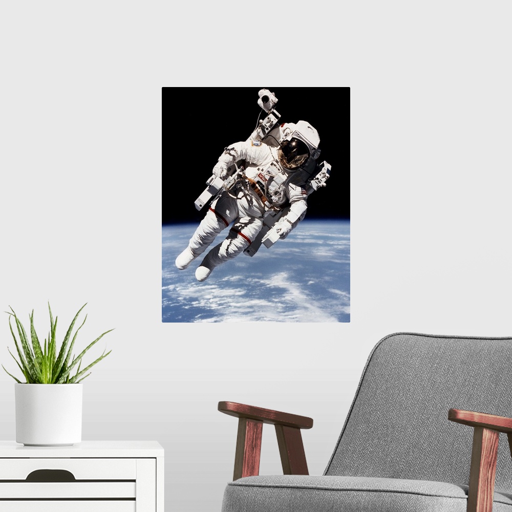 A modern room featuring Bruce McCandless floating free from spacecraft in orbit, 1984