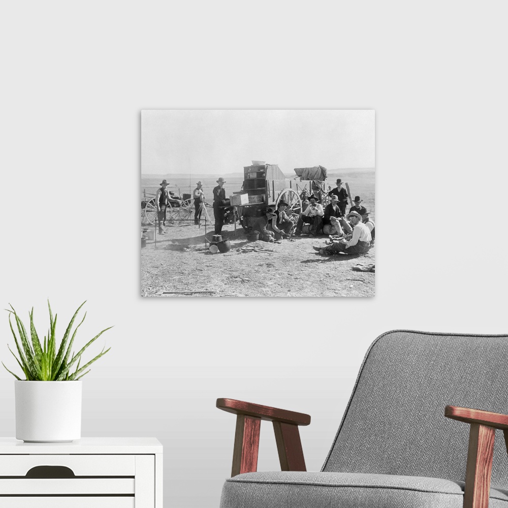 A modern room featuring Cowboy Camp, C1900. A Group Of Cowboys Sitting And Standing Beside A Chuckwagon At A Campsite Nea...