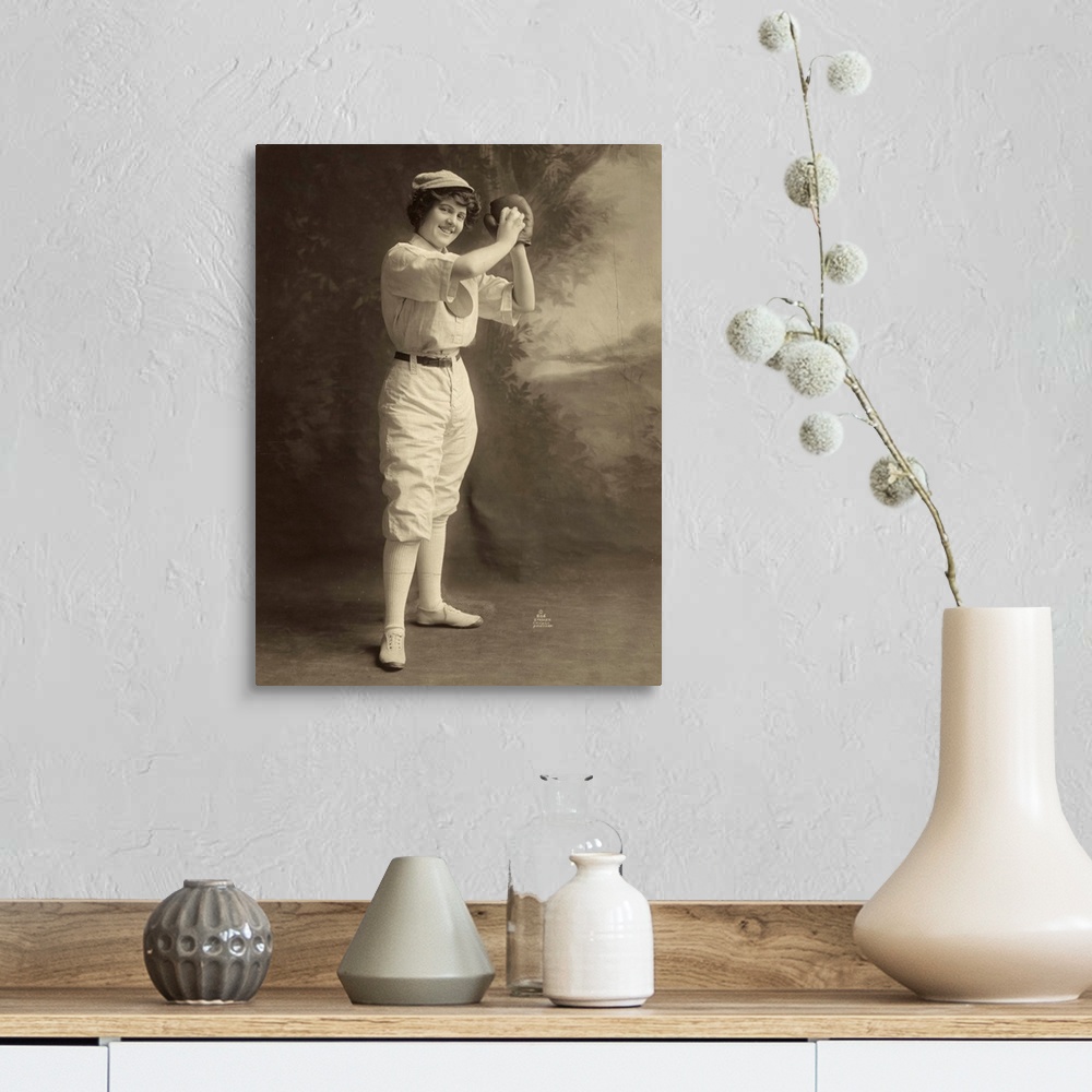 A farmhouse room featuring A female baseball player, in uniform, in a pitcher stance. Photograph, 1913.