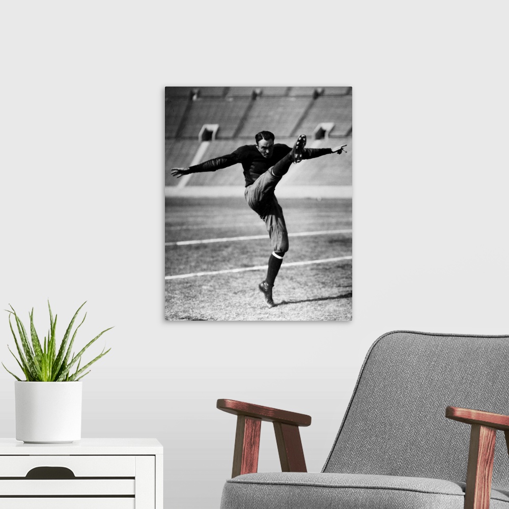 A modern room featuring An unidentified American football player kicking the ball, early 20th century.