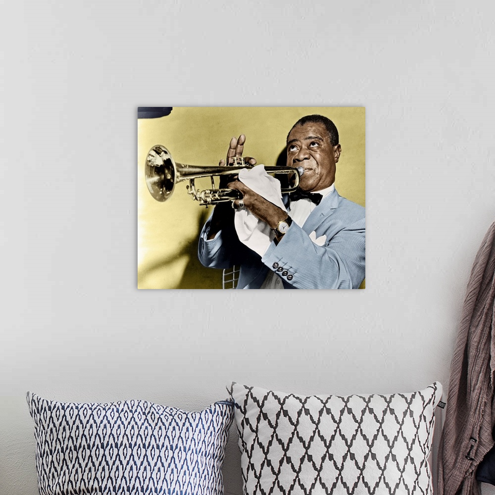 A bohemian room featuring LOUIS ARMSTRONG (1900-1971). American jazz musician. Photographed playing trumpet, 1953.