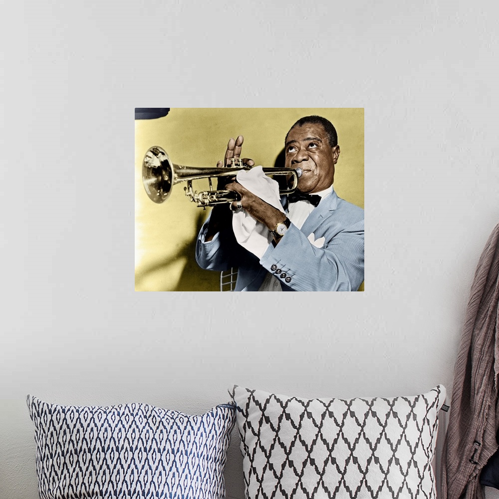 A bohemian room featuring LOUIS ARMSTRONG (1900-1971). American jazz musician. Photographed playing trumpet, 1953.