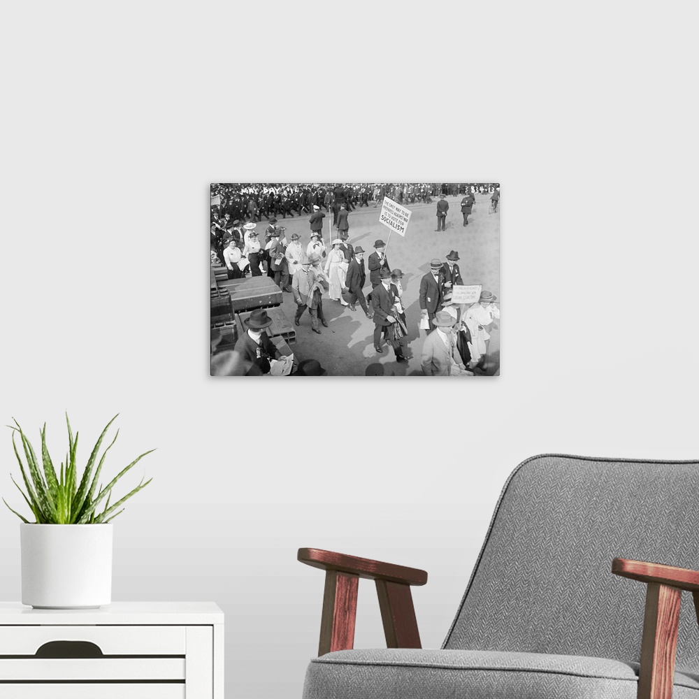 A modern room featuring Women and men marching at the May Day Parade as one man holds a sign promoting Socialism in New Y...