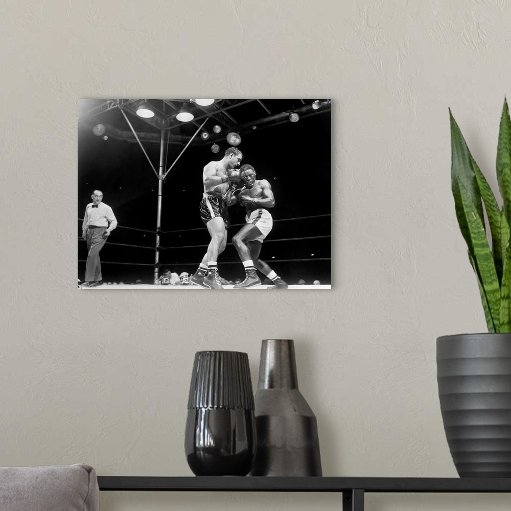 A modern room featuring Rocky Marciano (left) defending his heavyweight title in a fight against Ezzard Charles at Yankee...