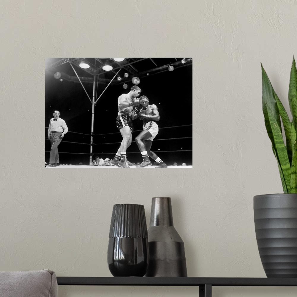 A modern room featuring Rocky Marciano (left) defending his heavyweight title in a fight against Ezzard Charles at Yankee...