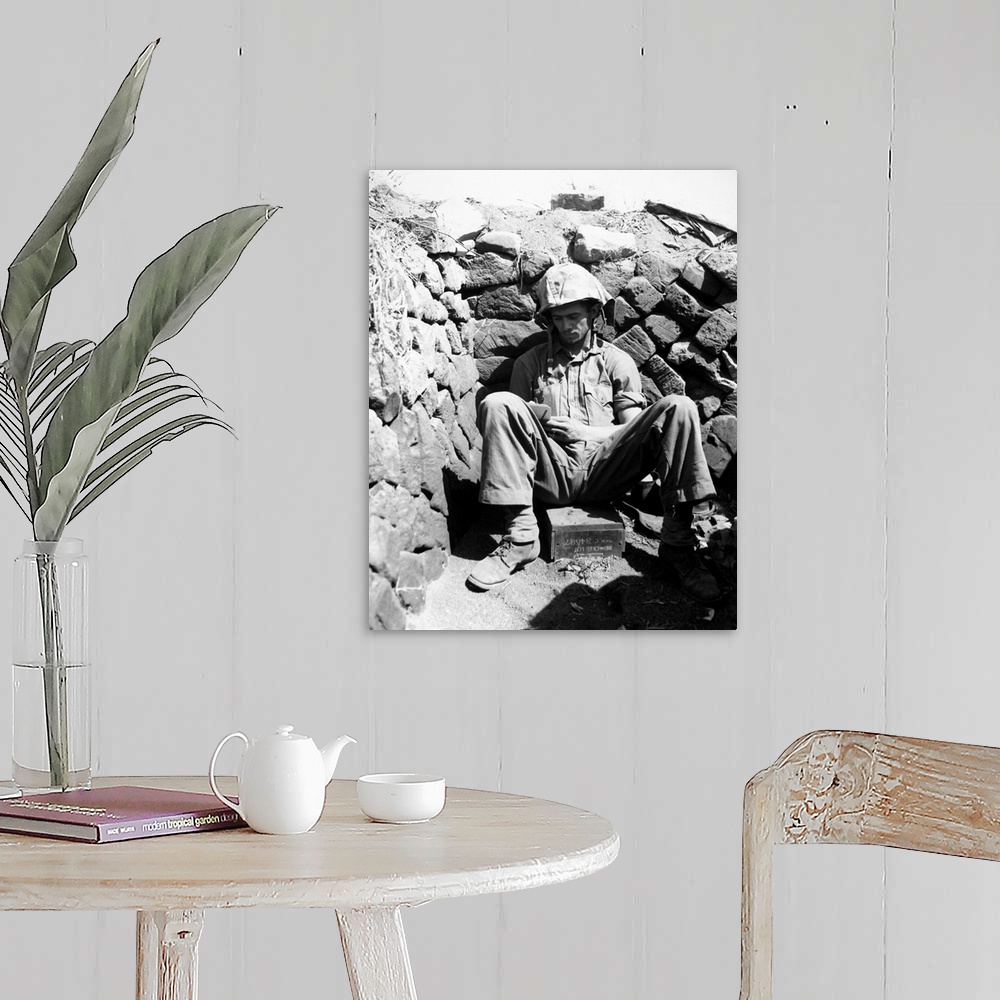 A farmhouse room featuring Portrait of U.S. Marine PFC Keith A. Cole sitting in a foxhole on Iwo Jima. Photograph, 1 March 1...