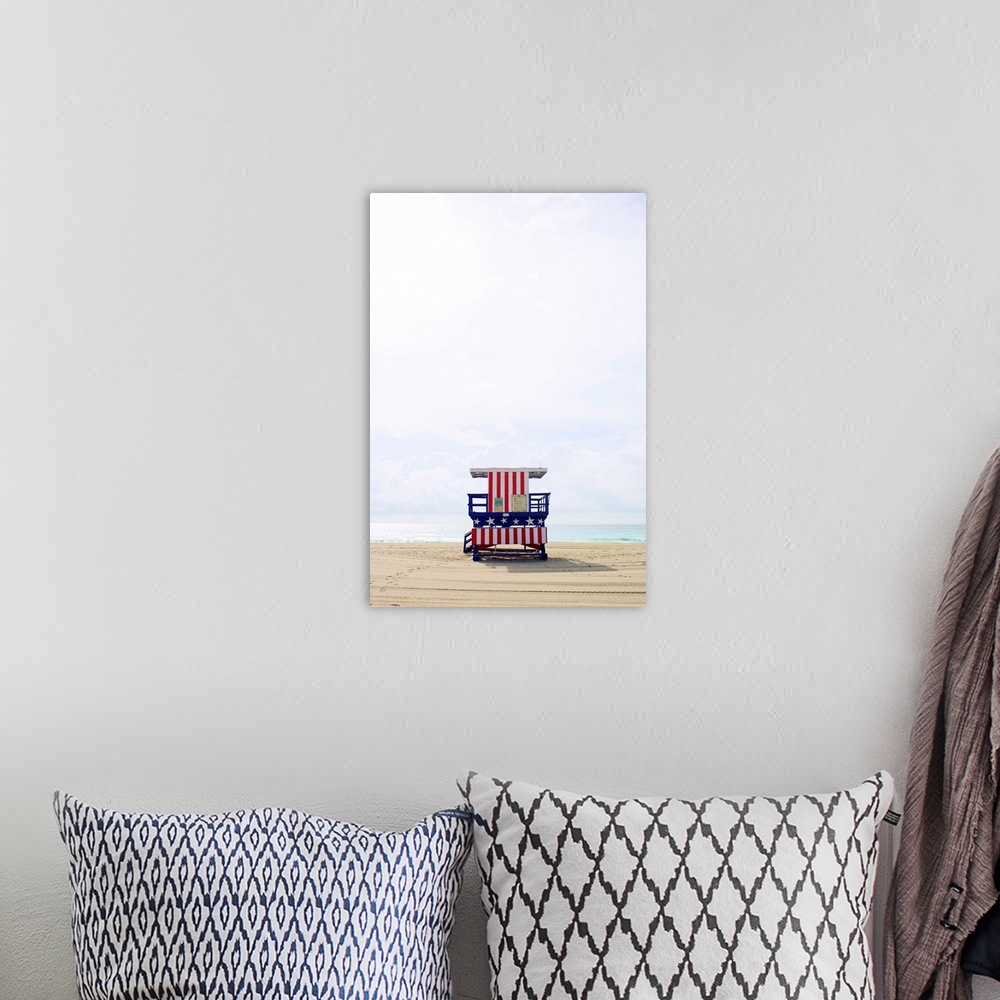 A bohemian room featuring Vertical photograph of an America themed lifeguard stand on an empty beach with calm waters and a...