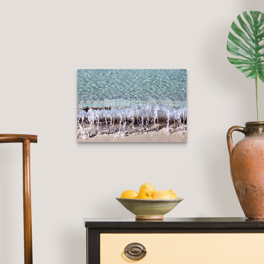 A traditional room featuring Photograph of a small wave hitting the shore of a beach.